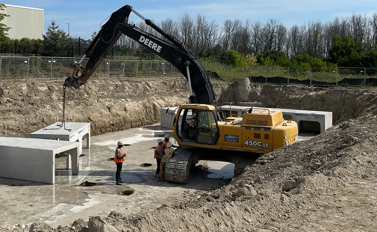 Excavator placing StormTrap SingleTrap units during installation in Ajax Ontario