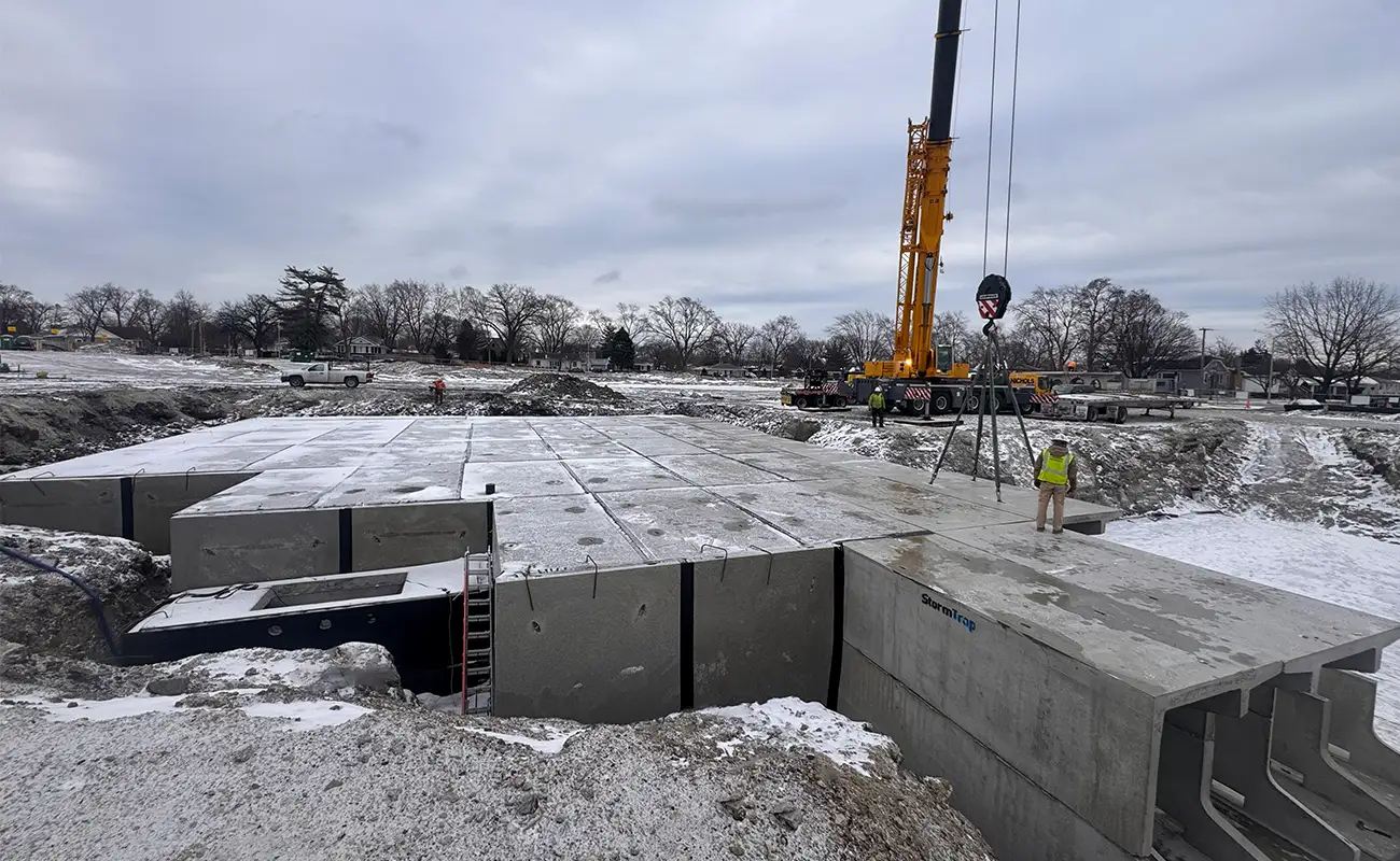 Aerial view of StormTrap underground stormwater detention basin with precast lid panels being placed by crane in Oak Lawn, Illinois