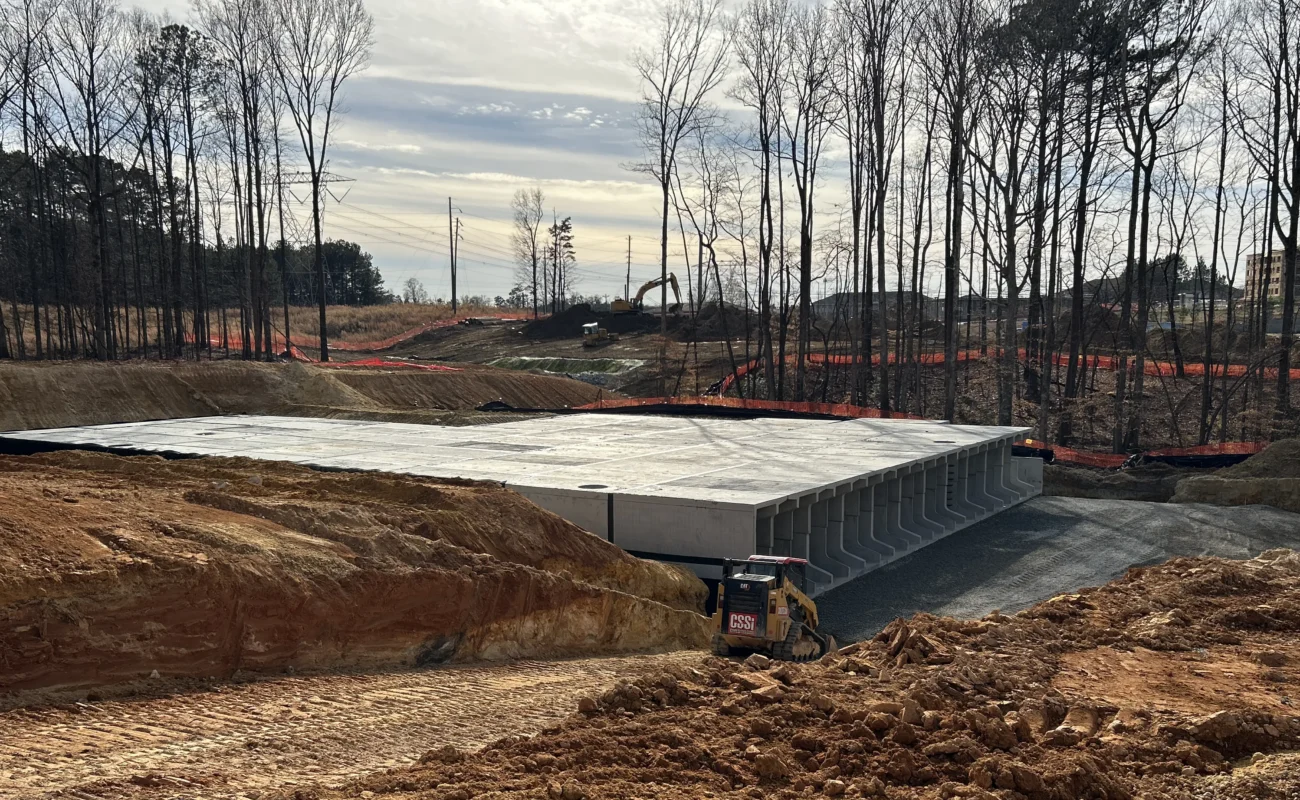 Wide site view of StormTrap DoubleTrap detention basin with lid panels being placed during construction at The Autry at Tulip Grove in Buford, GA