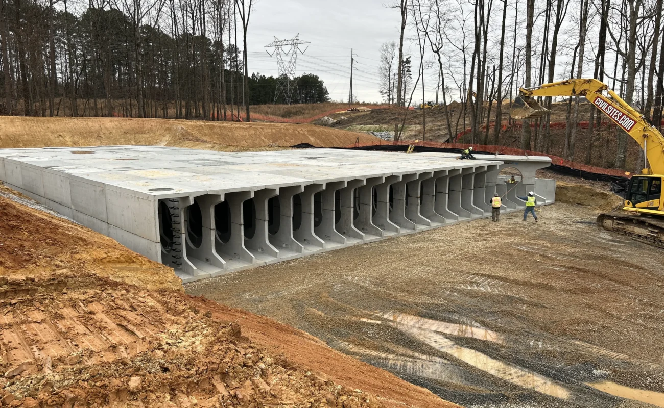 Aerial view of completed StormTrap DoubleTrap underground detention basin with construction crew and excavator at The Autry at Tulip Grove in Buford, GA