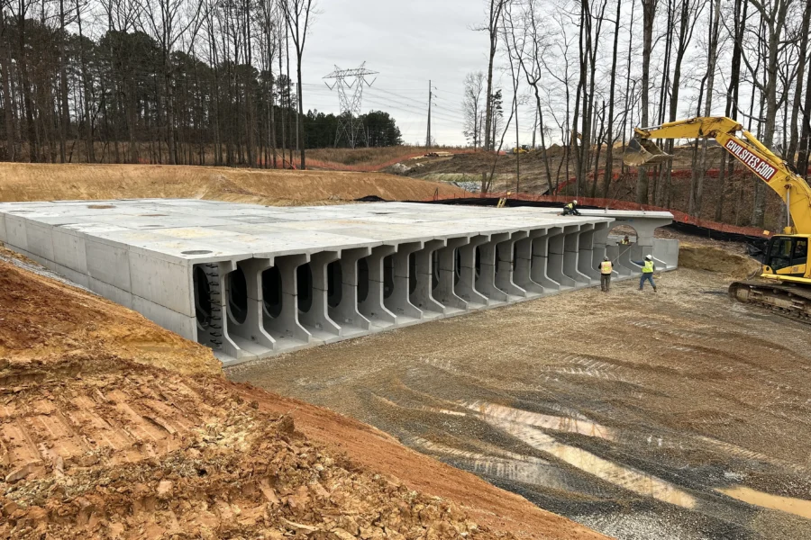 Aerial view of completed StormTrap DoubleTrap underground detention basin with construction crew and excavator at The Autry at Tulip Grove in Buford, GA
