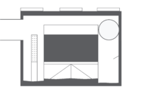 Simple black and white floor plan illustration with a large central rectangle, three small rectangles at the top, and a large circle in the top right corner.
